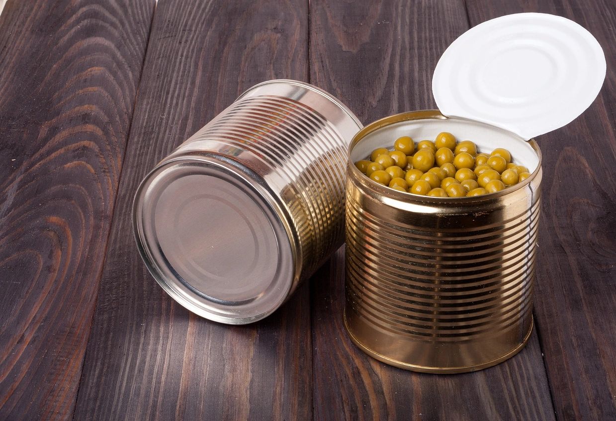 canned green peas in a bank on wooden table.